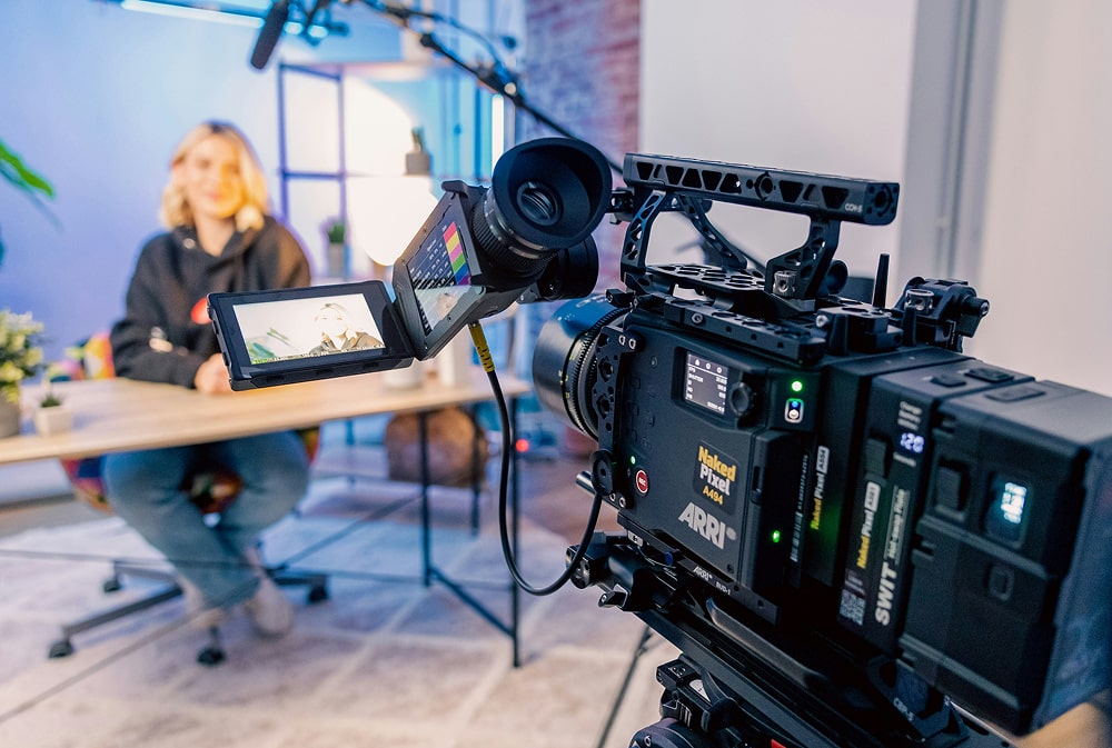Young woman creating content with camera setup, illustrating the rise of immersive and interactive video marketing blending entertainment and commerce.